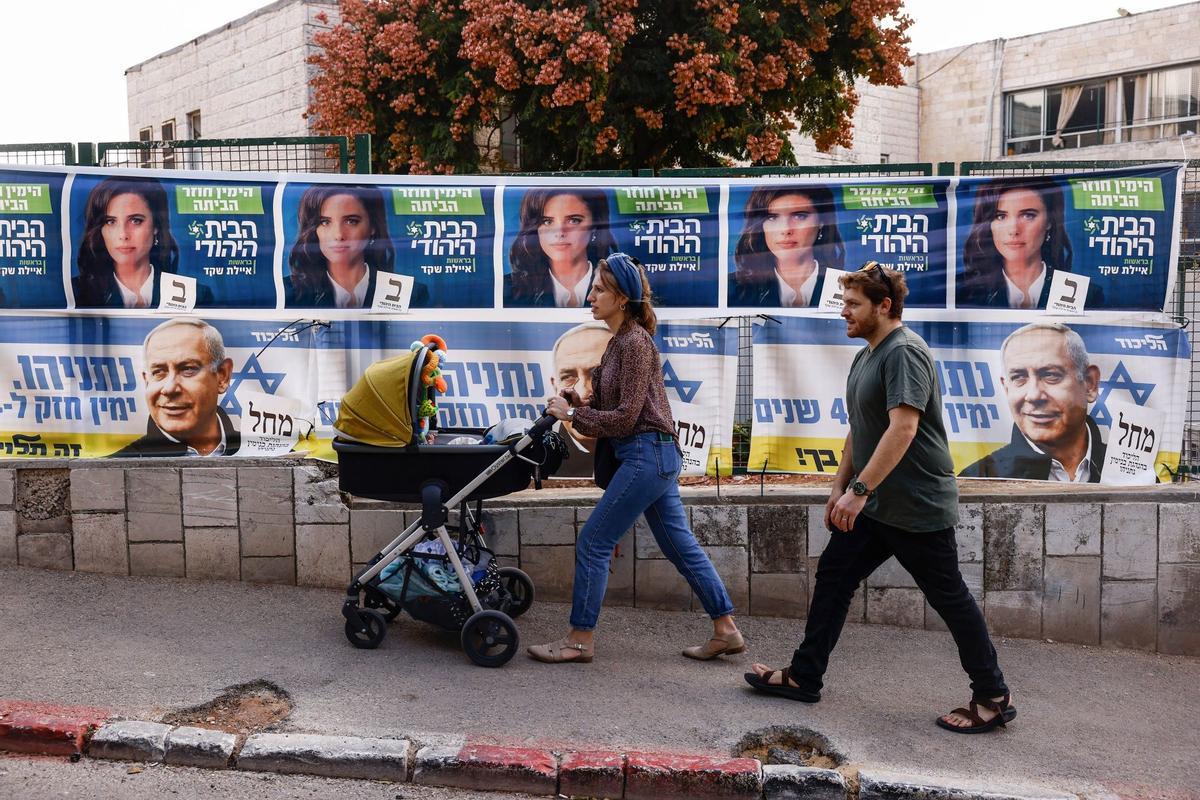 Unos votantes pasan frente a los carteles electorales del partido Likud frente a un colegio electoral en Jerusalén. Los israelíes comenzaron a votar el martes en sus quintas elecciones generales desde 2019, con el ex primer ministro Benjamin Netanyahu planeando su regreso como parte de una alianza que podría empoderar a la extrema derecha de la nación.