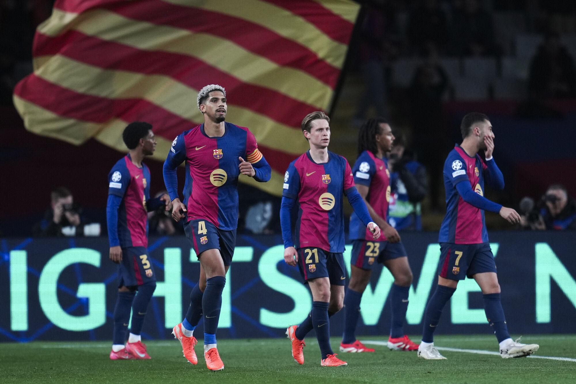 Barcelona's Ronald Araujo, left, celebrates after scoring his side's second goal during a Champions League opening phase soccer between Barcelona and Atalanta match at the Lluis Companys Olympic stadium in Barcelona, Spain, Wednesday, Jan. 29, 2025. (AP Photo/Emilio Morenatti)