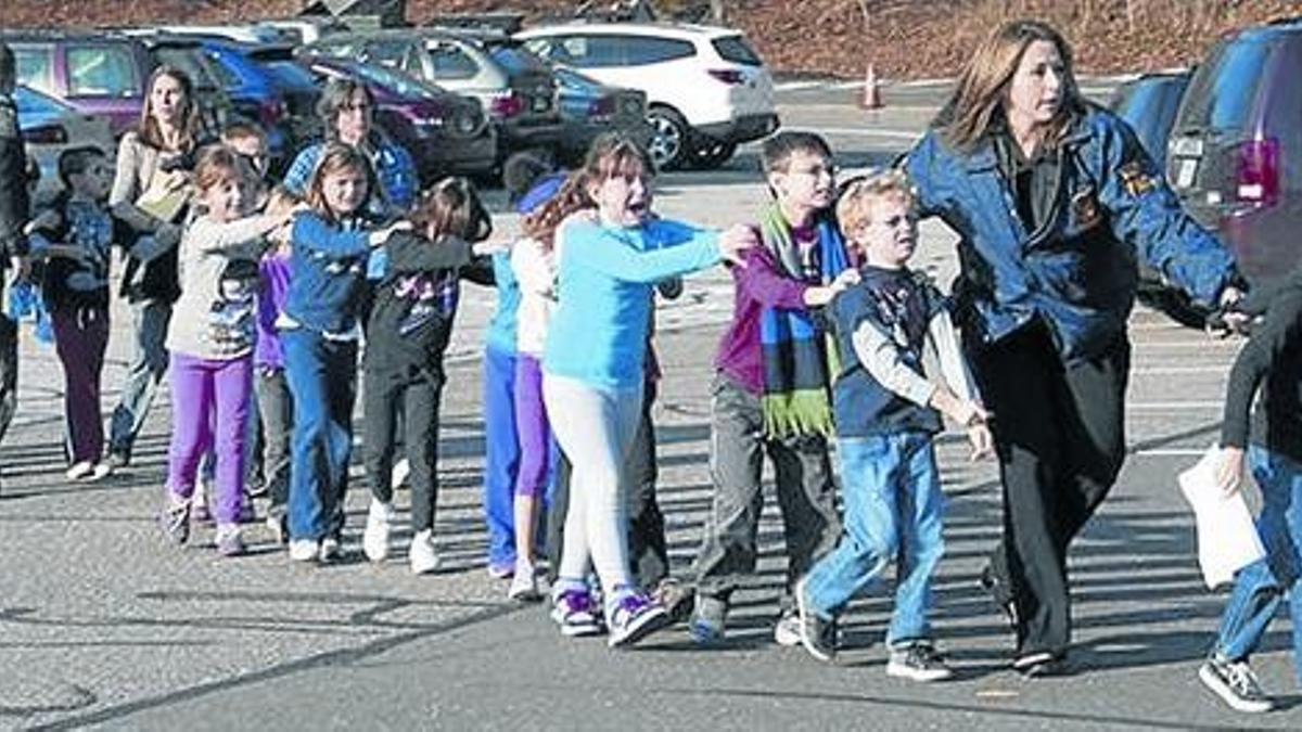 La policía de Newtown, Connecticut, evacúa a un grupo de alumnos del Sandy Hook, tras el tiroteo del 2012.