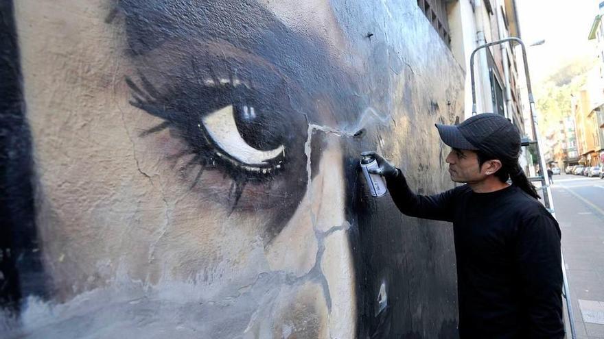 César Frey con el grafiti que está restaurando.