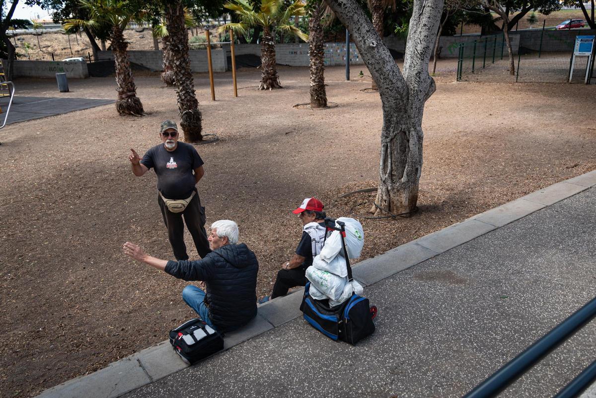 Francisco, de pie, habla con Enrique y Jesús, de espaldas, en el parque Manuel Castañeda.