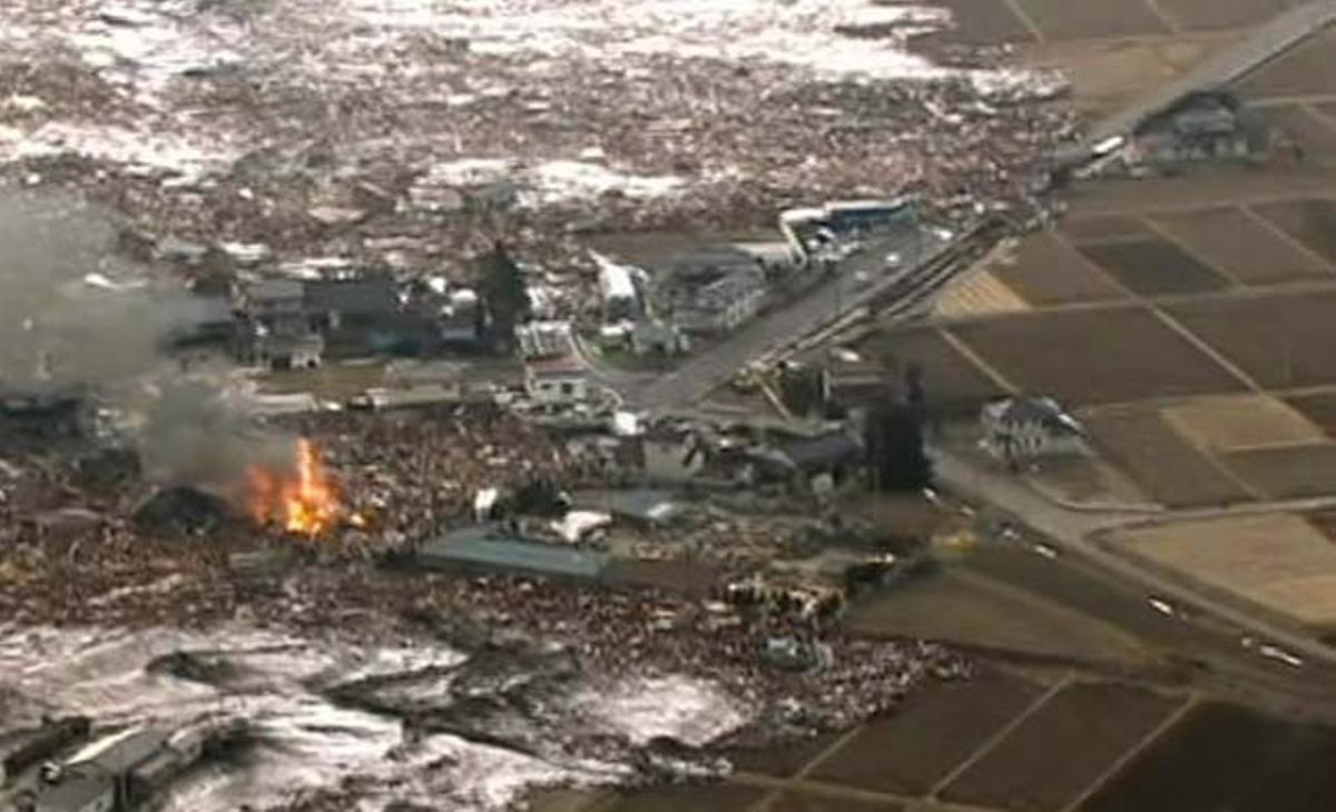 Un grup de cases en què s’havia declarat un incendi després del terratrèmol rep l’impacte de l’onada gegant a Sendai, a la prefectura de Miyagi, a l’est del Japó. Un grup de cases en què s’havia declarat un incendi després del terratrèmol rep l’impacte de l’onada gegant a Sendai, a la prefectura de Miyagi, a l’est del Japó.