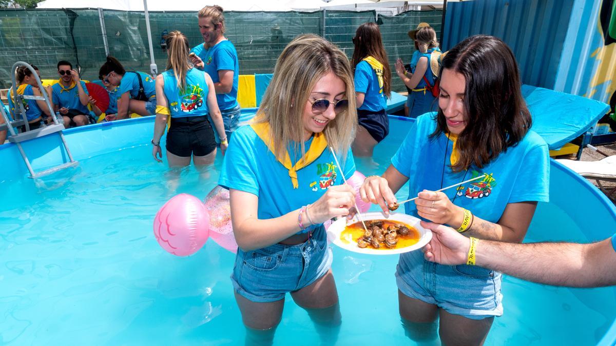 Anna y Mariona, de la colla Aspavil, comen caracoles en una piscina, ante las altas temperaturas, durante la celebración del Aplec del Caragol en Lleida