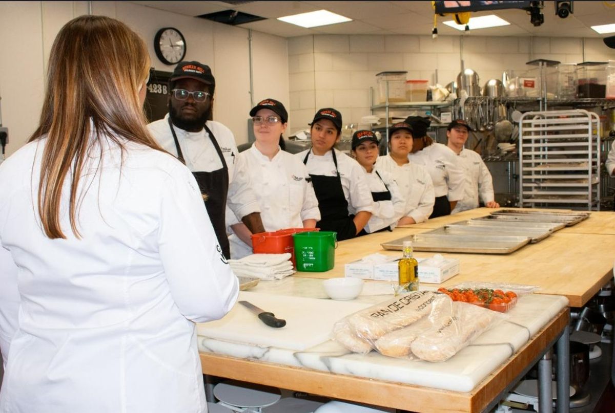 Asistentes a un 'showcooking' en Boston aprenden a preparar el pan con tomate.
