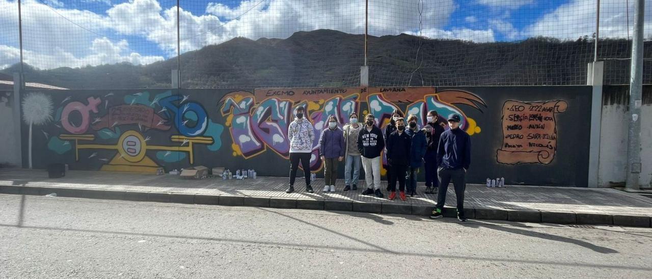 El mural realizado en Laviana, con sus autores. En el circulo, la exposición del colegio Maximiliano Arboleya de Barredos. |