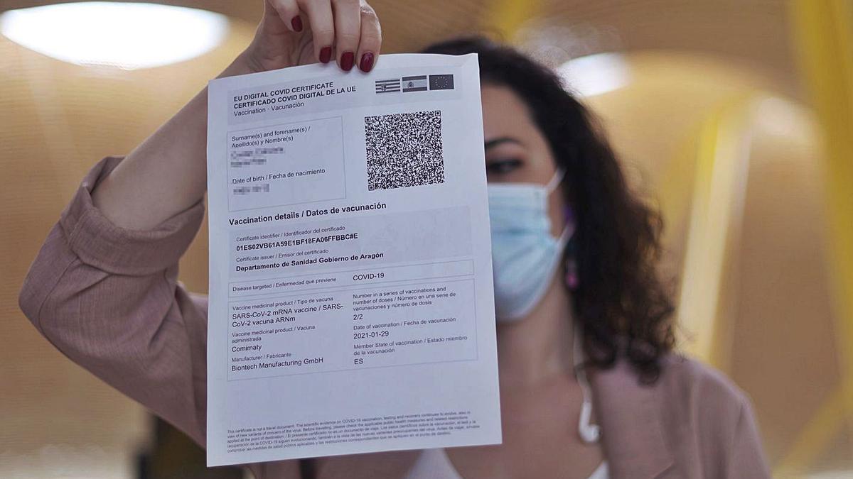 Una mujer mostrando su pasaporte covid el primer día de su entrada en vigor en julio. | EDUARDO PARRA