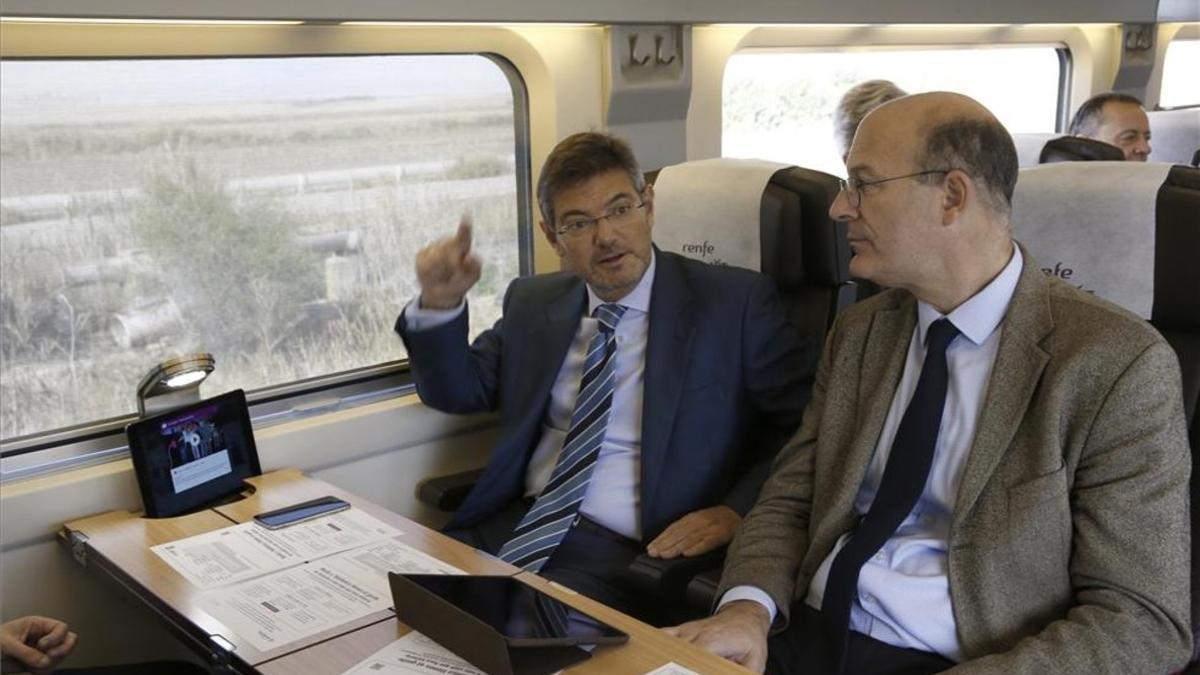 El ministro de Fomento en funciones, Rafael Catalá (izquierda), conversa con el presidente de Renfe, Pablo Vázquez, en el AVE donde han presentado el servicio de wifi.