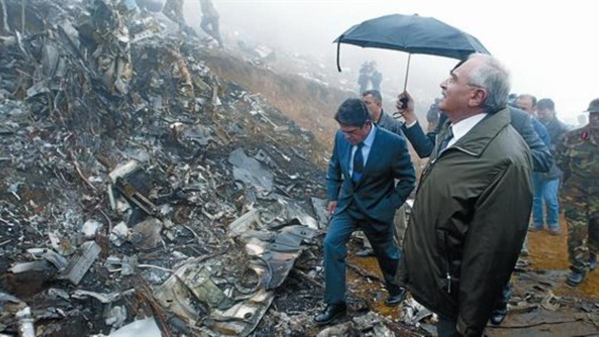 El entonces ministro de Defensa, Federico Trillo, y su homólogo turco, Vecdi Gonul, pisan los restos del Yak-42 , en el monte Pilav, el 27 de mayo del 2003.