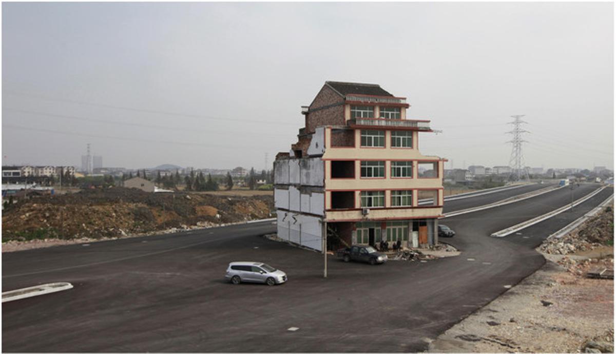 Una casa obliga a bordear una carretera en Wenling, ya que sus propietarios se niegan a demolerla.