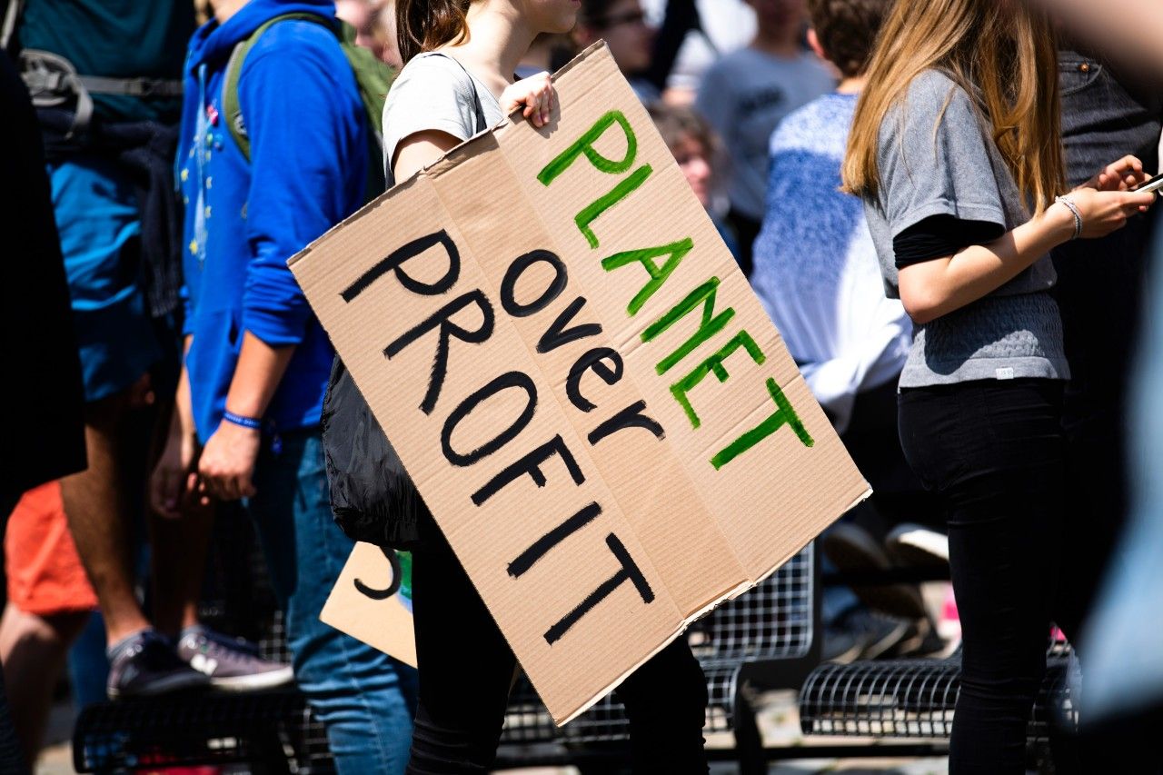 Manifestante exhibe un cartel con el lema 'El planeta antes que el beneficio&quot;