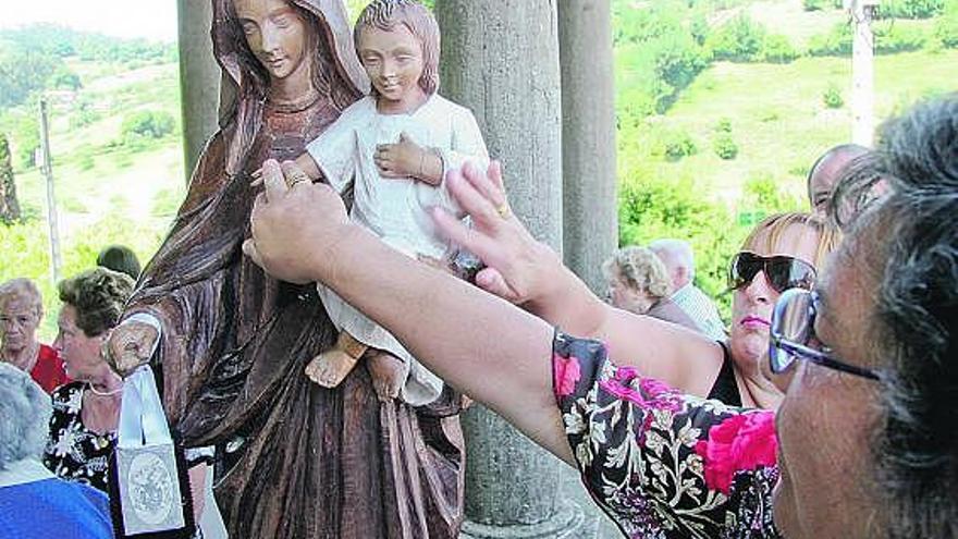 Algunas mujeres, ayer, tocando la imagen de Nuestra Señora del Carmen en la capilla de Llantones.