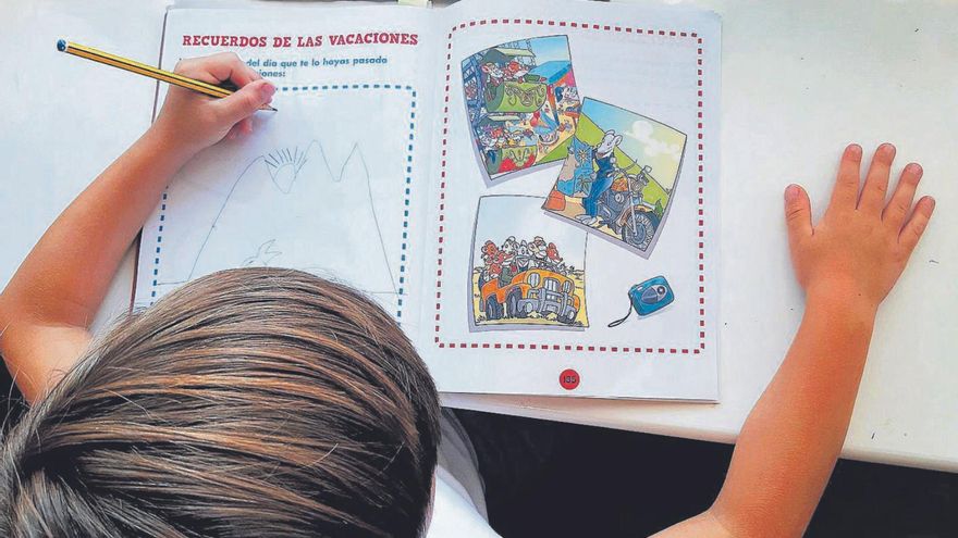 Un niño de siete años escribe los recuerdos de sus vacaciones en un cuaderno. | // MANU MITRU