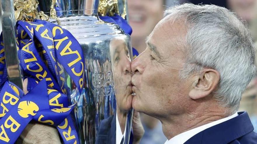 El entrenador italiano Claudio Ranieri besa el título de la Premier ganado por el Leicester.