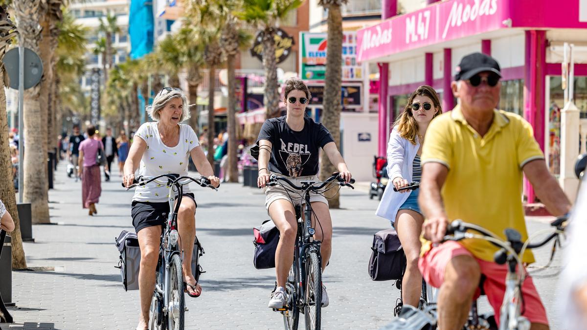 Turistas en bicicleta por el paseo marítimo de Benidorm en una imagen reciente.