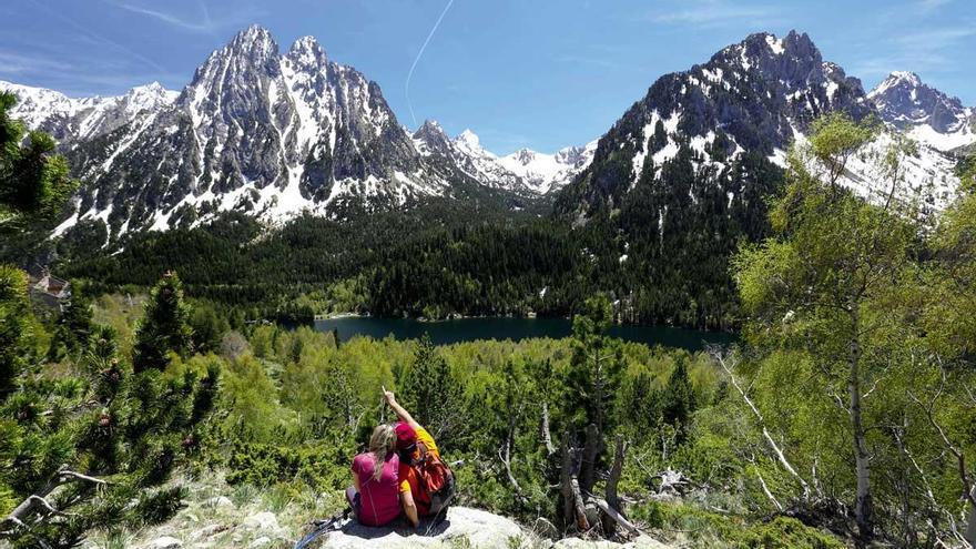 Una pareja de excursionistas admira Els Encantats, la montaña más emblemática de Aigüestortes.