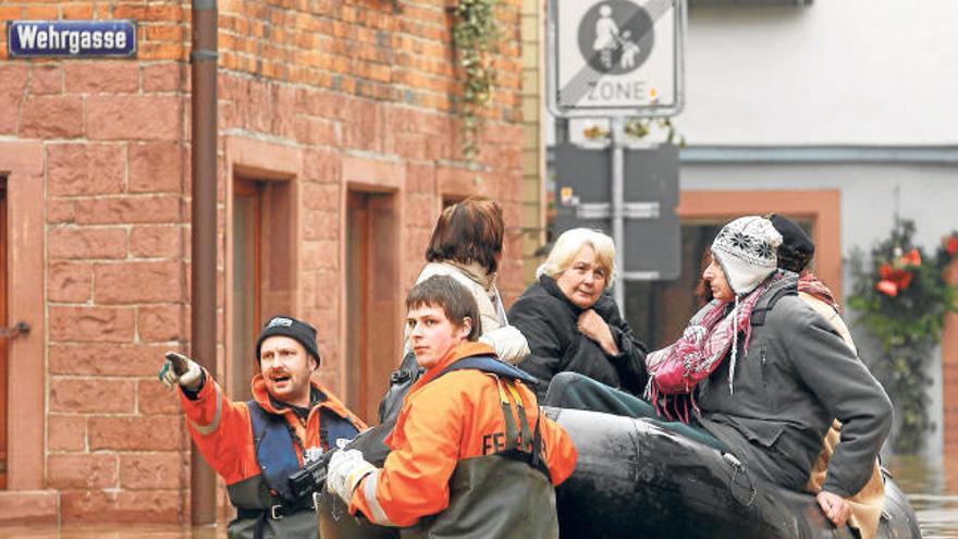 Varias personas son rescatadas en un bote en una calle anegada, ayer en Wertheim (Alemania).