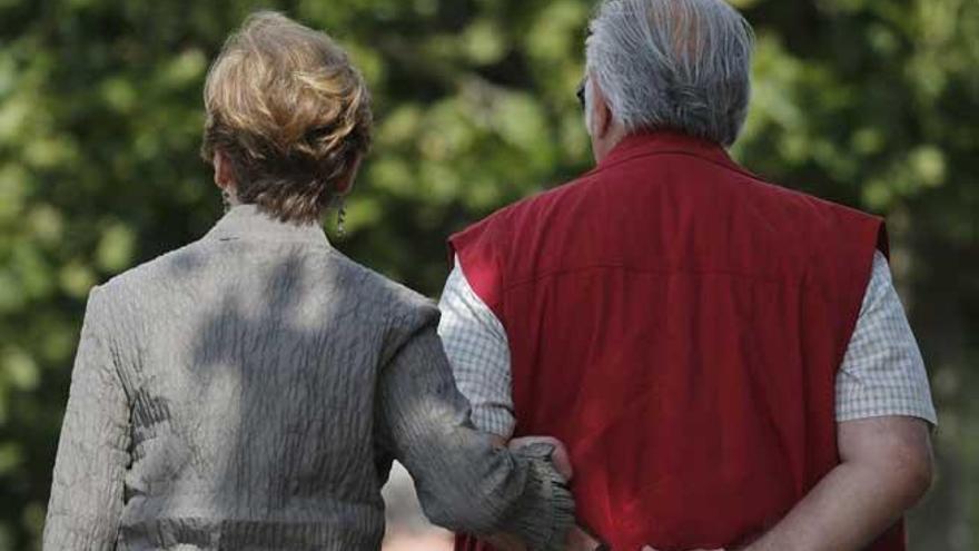 Dos personas mayores pasean por el parque.