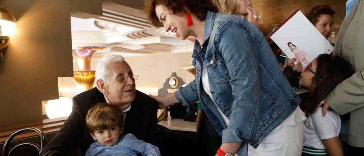 El escritor Luis Fernández Roces, con un niño en brazos, charla con la concejala de Cultura, Montserrat López Moro, antes del comienzo del acto.