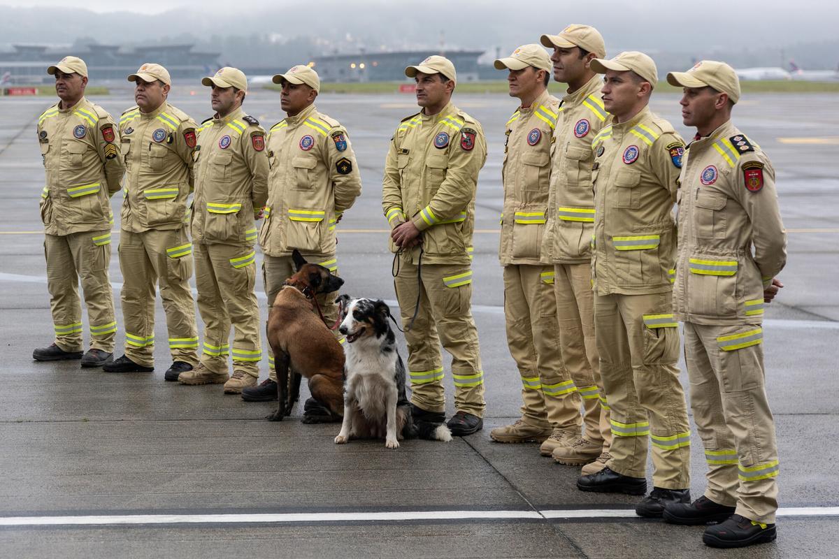 Bomberos Militares y sus caninos se preparan para embarcar un avión militar este viernes, en la Base Aérea de São Paulo.