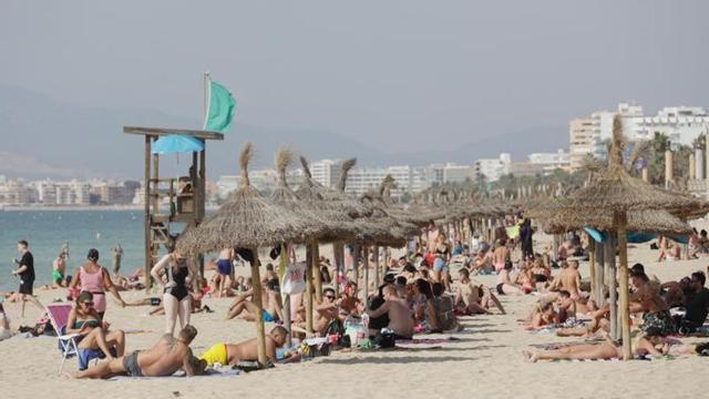 Turistas disfrutando en la Platja de Palma. | MANU MIELNIEZUK