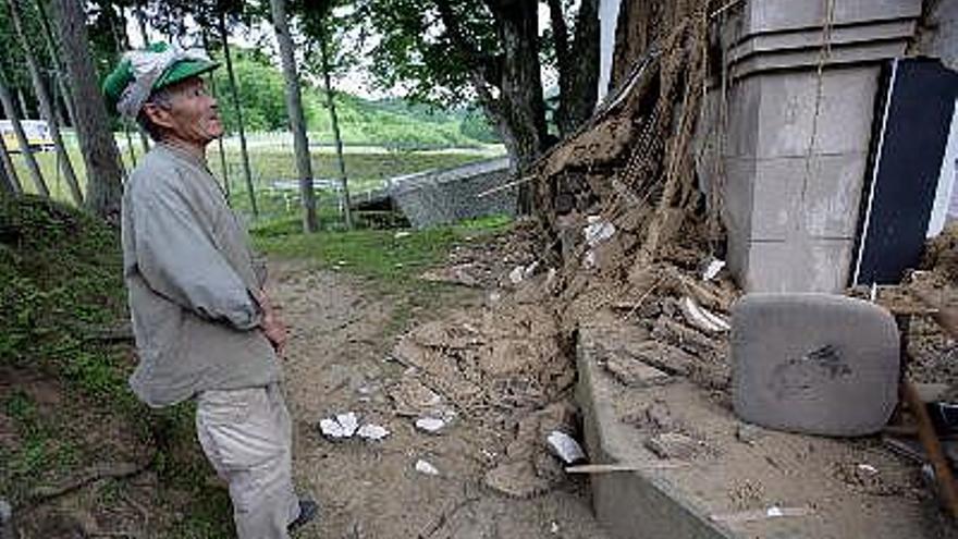 El agricultor japonés Takejiro Nigorinuma, de 77 años de edad, echa un vistazo a los destrozos de su casa y de su almacén en Kurihara, Japón, después de que un terremoto azotara el norte de Japón. Según un reportero, tres personas has muerto otras diez han desaparecido.