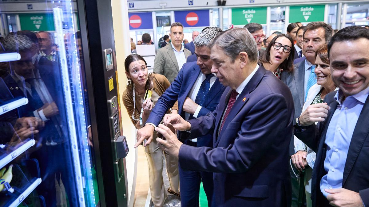 El ministro de Agricultura, Luis Planas, compra un plátano canario en la Fruit Attraction con la ayuda de Narvay  Quintero.