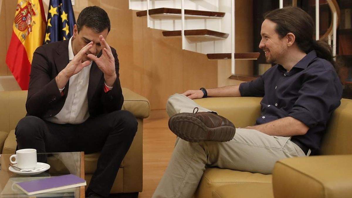 Pablo Iglesias escucha a Pedro Sánchez durante su reunión en el Congreso.