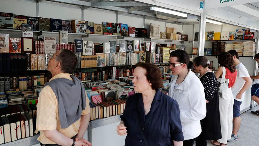 Transeúntes parados ante la caseta de la Librería Quin de Joaquín Sardá en la Feria. // J.Lores