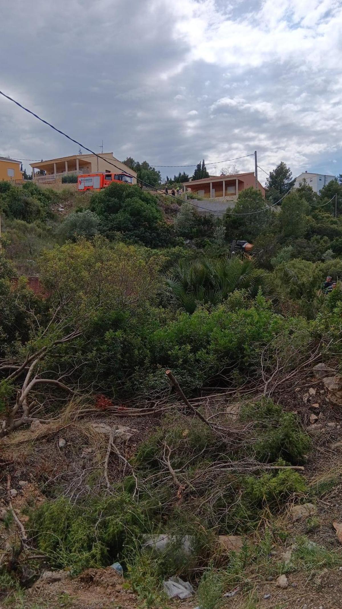 La excavadora accidentada, a la derecha y, arriba, un camión de bomberos.