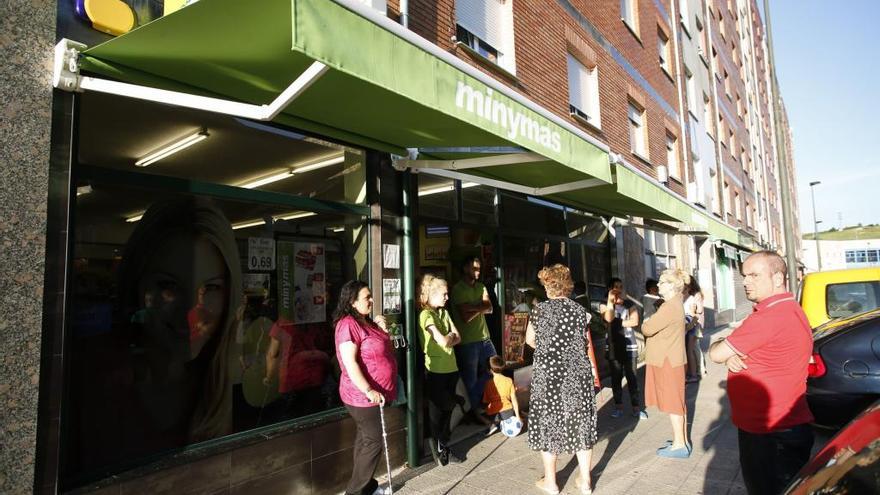 Vecinos ante el supermercado asaltado tras el robo, en agosto de 2016.