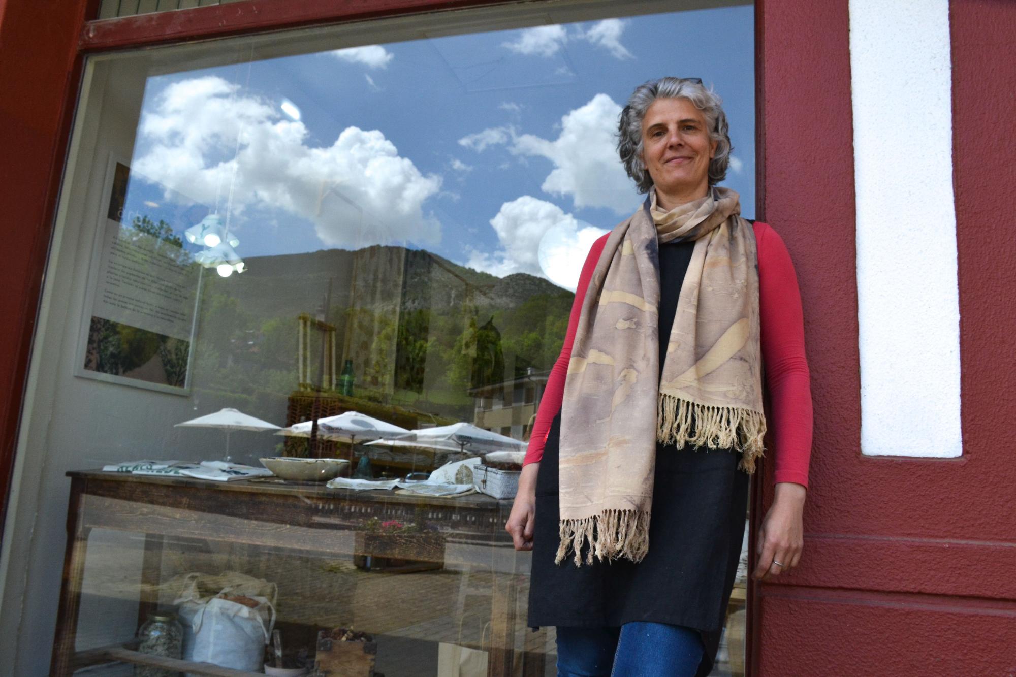 Sandra Ramiro, en el exterior de su tienda, con el paisaje reflejándose en su escaparate.