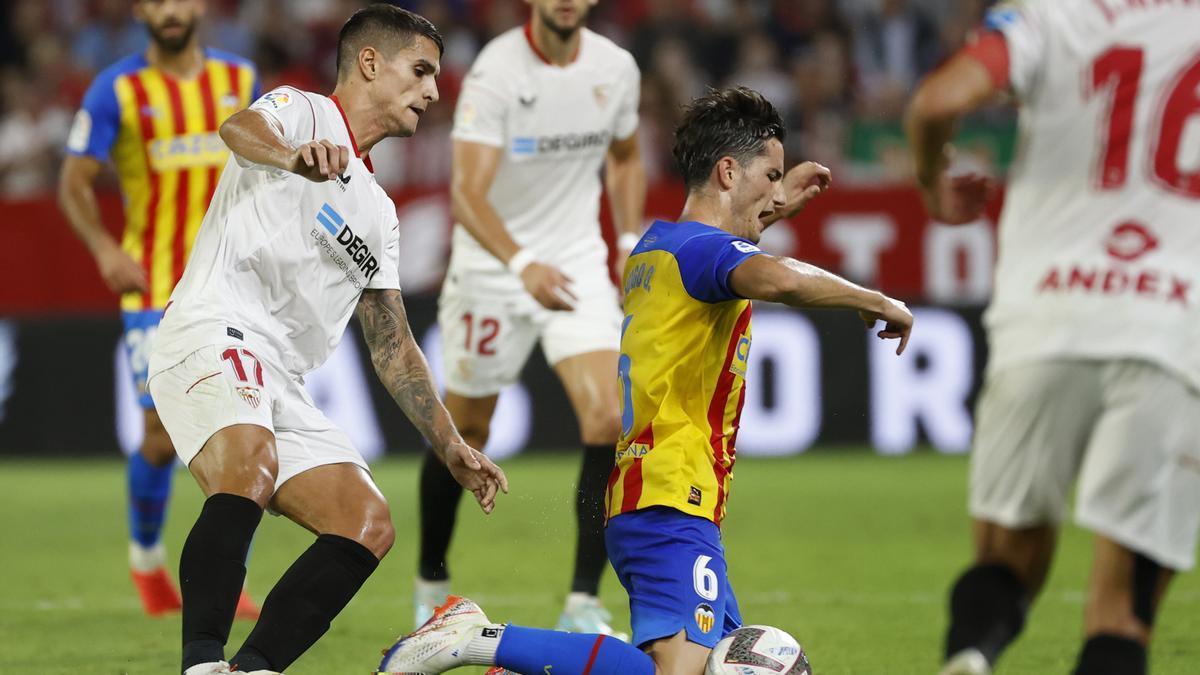 Jugadores del Sevilla y del Valencia disputan un balón.