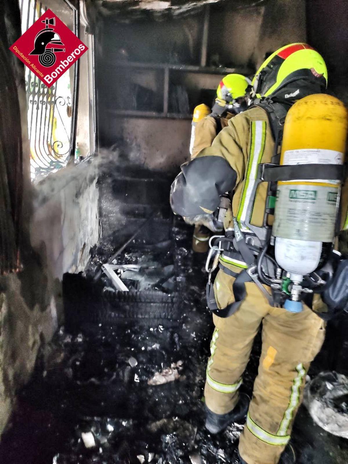 Varios bomberos, en el interior de la vivienda donde se ha producido este suceso.