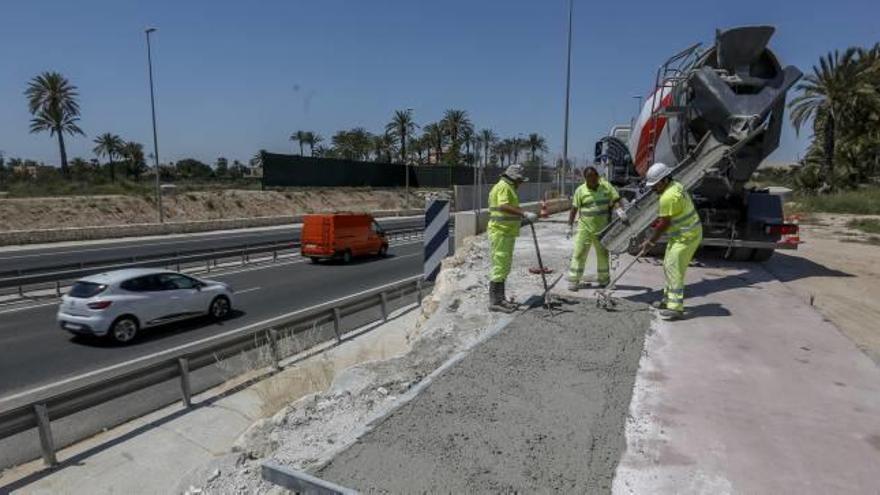 Operarios rellenando con hormigón un tramo del carril bici de la Ronda Sur, que sufrió desperfectos por los temporales de lluvia.