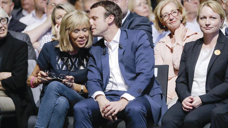 Emmanuel Macron habla al oído a su mujer durante un acto político en esta campaña presidencial.