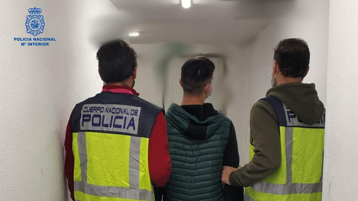Agentes de la Policía Nacional llevan detenido a uno de los ladrones de un colegio de Alicante.