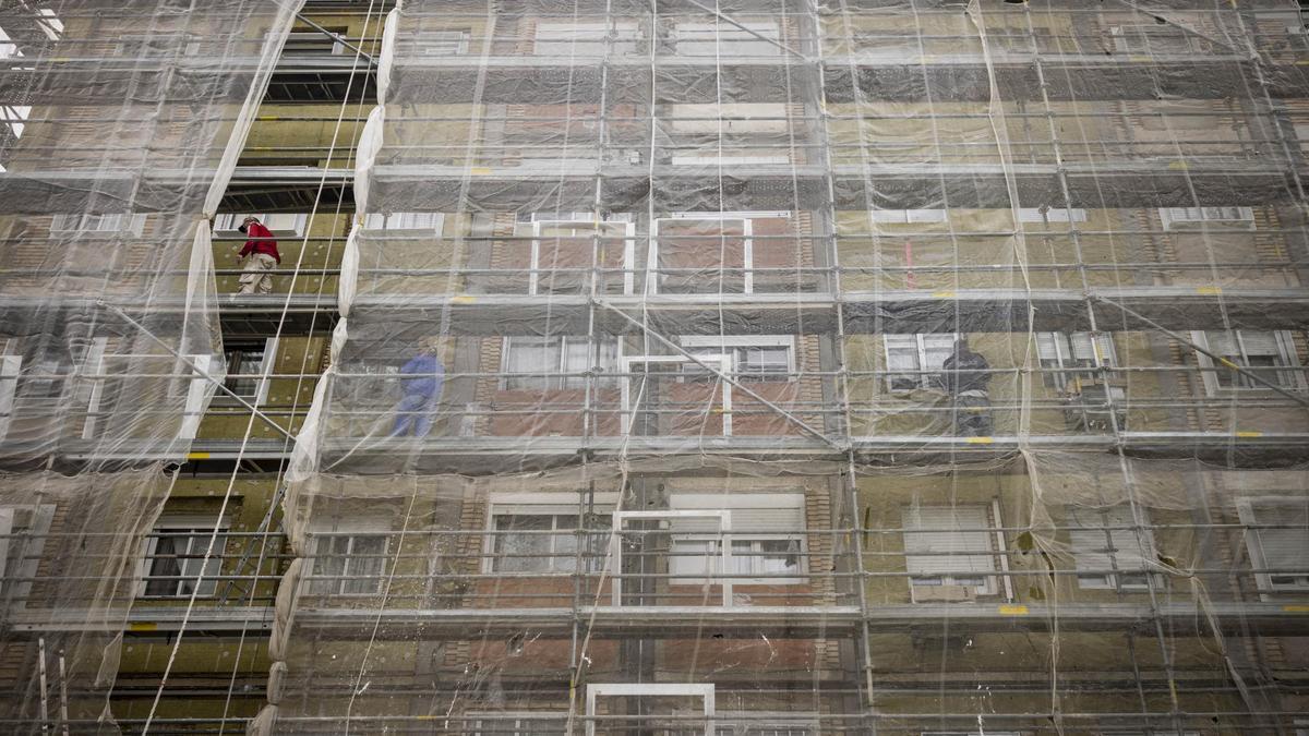 Varios trabajadores subidos al andamio en las obras de una fachada que se llevan a cabo en un edificio residencial de Zaragoza.