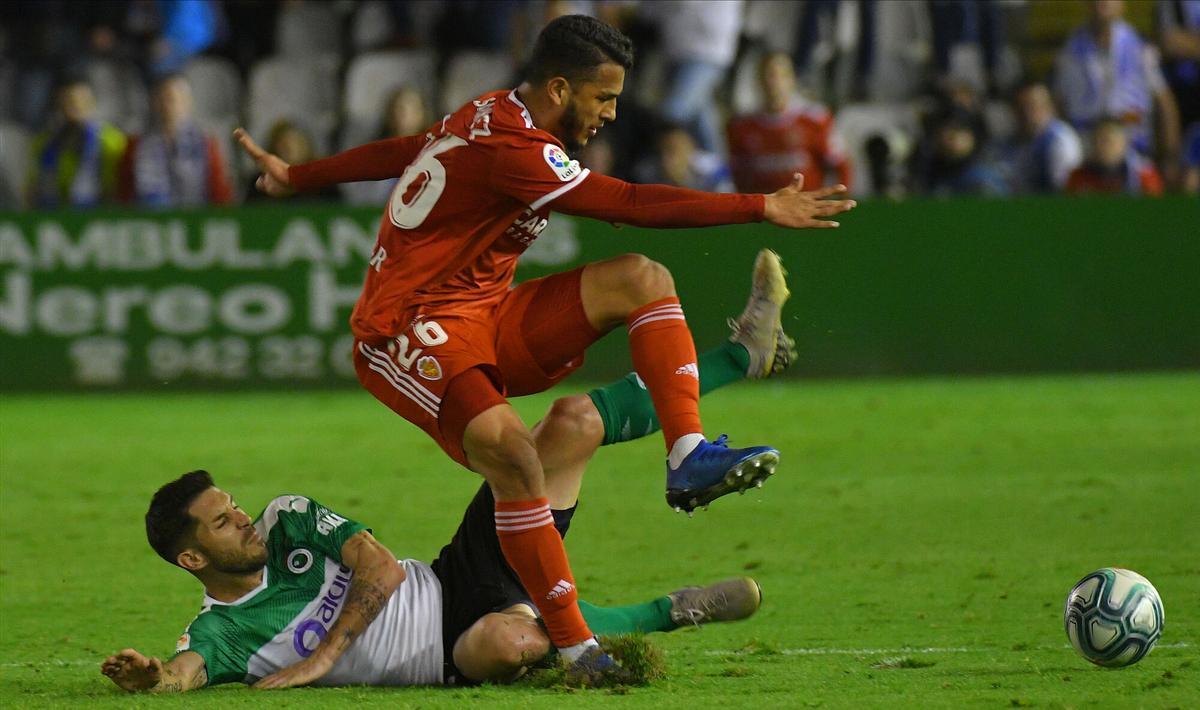Luis Suárez pugna el balón con un jugador del Racing de Santander