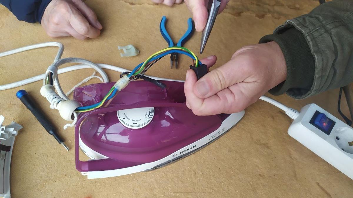 Usuarios reparan una plancha en un espacio de reparación colectiva