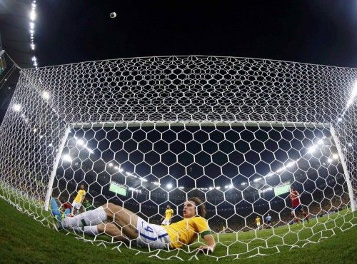 Brazil's David Luiz slides into the net after making a goal line clearance during their Confederations Cup final soccer match against Spain at the Estadio Maracana in Rio de Janeiro