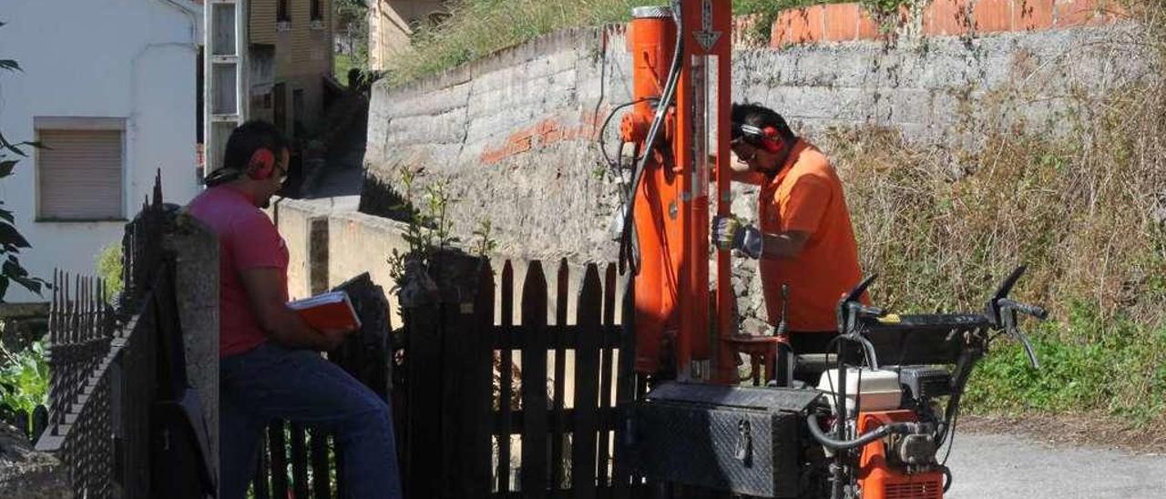 Dos operarios realizan un sondeo en una de las zonas con grietas en Boo.