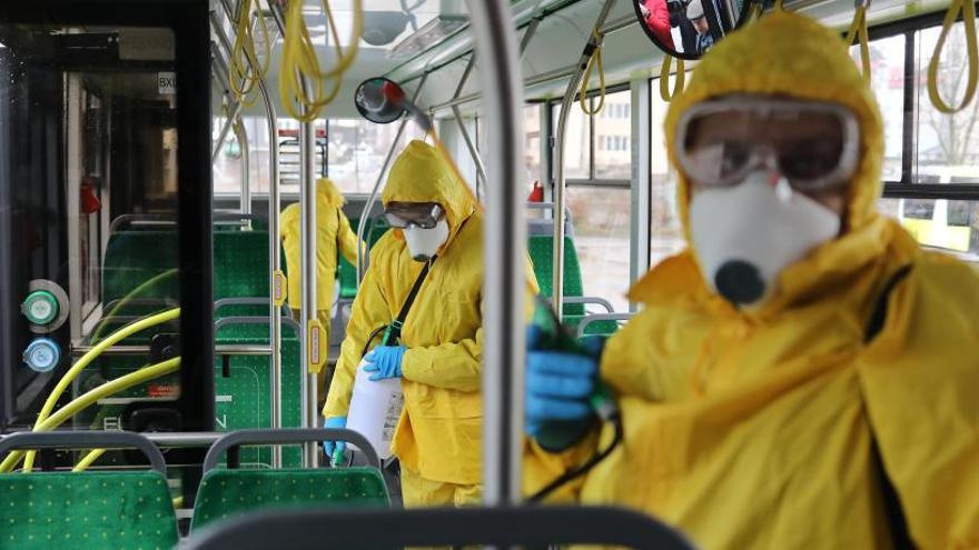 Treballadors desinfectant un autobús.