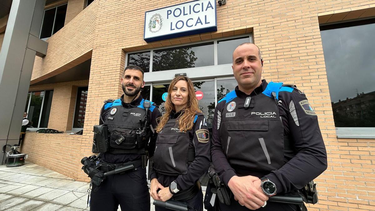 Los agentes Héctor Suárez y Héctor Blanco flanquean a su compañera Paula López frente a la comisaría de la Policía Local de Castrillón.