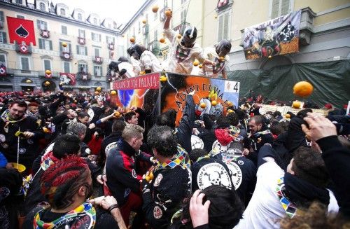 Miembros de equipos rivales luchan con naranjas durante una batalla de carnaval en el norte de Italia