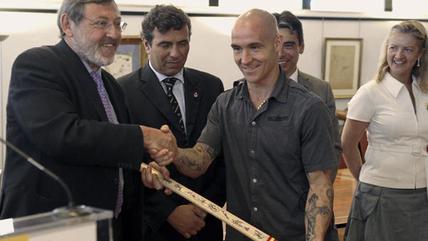 El secretario de Estado para el Deporte, Jaime Lissavetzky (izda), recibe un stick de manos de Pedro Gil (c), capitán del equipo español de hockey