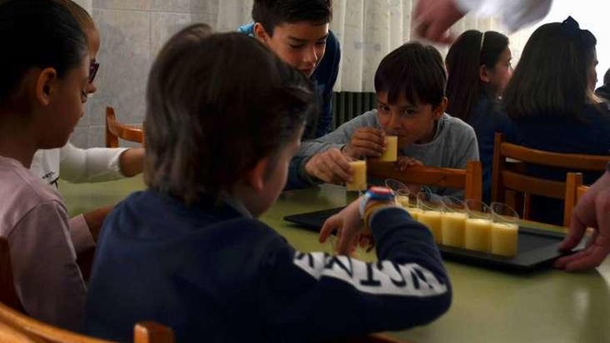 Varios escolares probando el zumo de piña y coco.