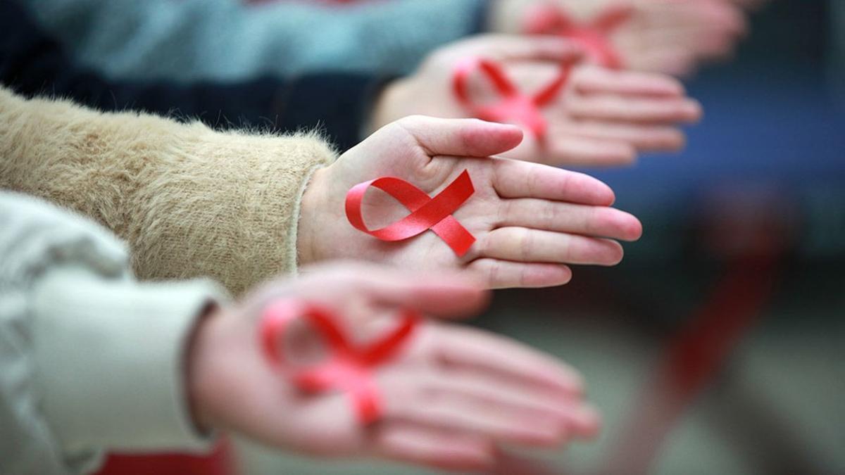 Estudiantes de la Universidad de Yangzhou (China) muestran cintas rojas para promover la prevención del sida, ayer