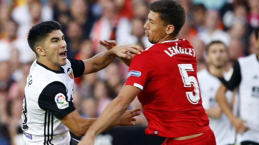 Carlos Soler disputa el balón con Clement Lenglet.