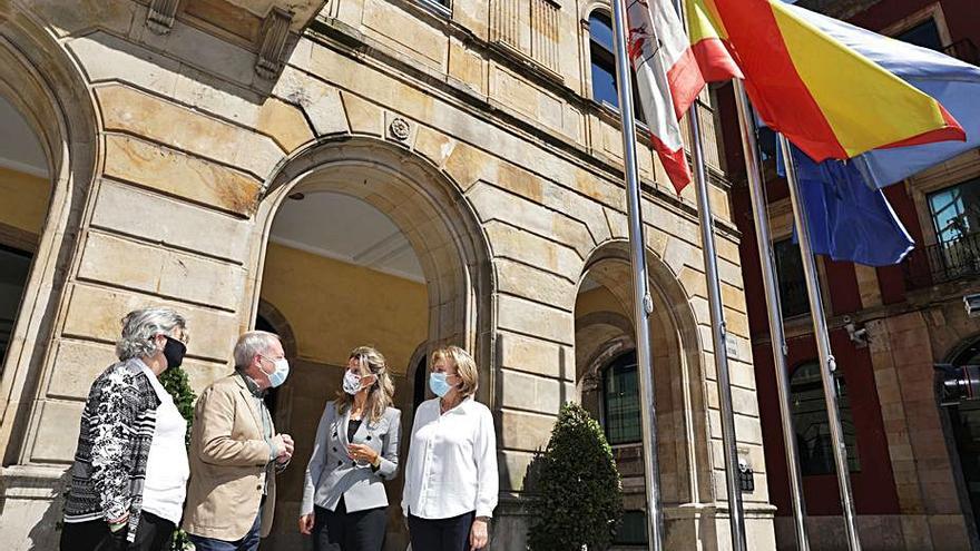 Ana González y Aurelio Martín charlan con Yolanda Díaz ante la mirada de Delia Losa a las puertas del Ayuntamiento de Gijón. | Juan Plaza