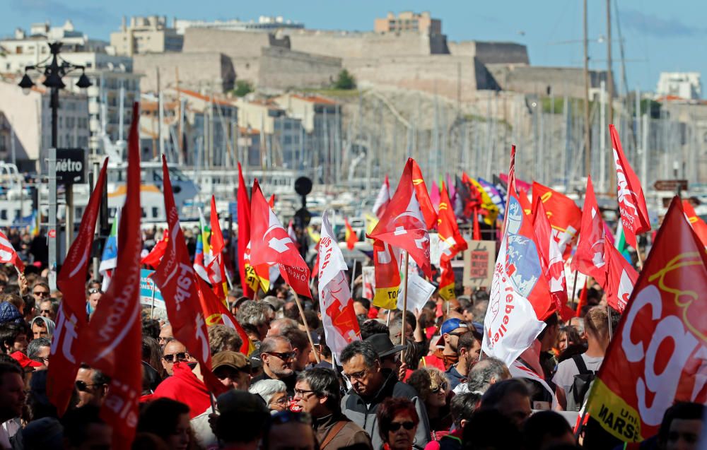 Demonstrators walk behind banners as part of ...